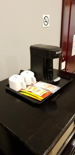 a black counter top with a coffee maker and cups at Best Western Plus Belize Biltmore Plaza in Belize City