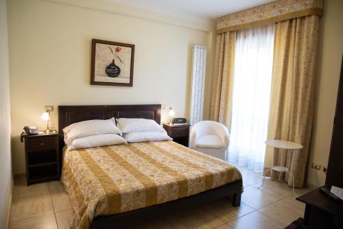 a bedroom with a bed and a chair and a window at Bellavigna Country House in Montefalcione