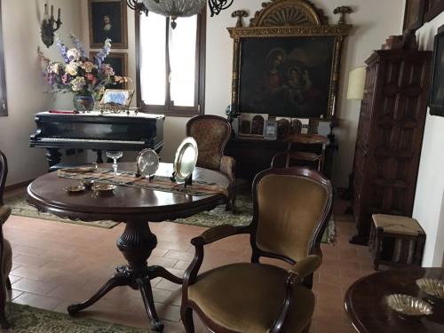 a living room with a table and a piano at Casa Madonna Boschi in Poggio Renatico