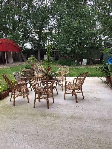 a group of chairs and a table with an umbrella at Casa Madonna Boschi in Poggio Renatico