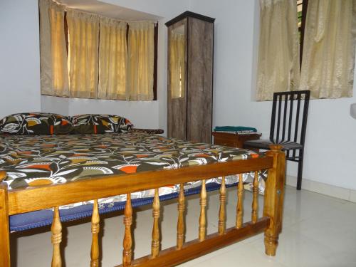 a bedroom with a wooden bed and a chair at Montecello in Trivandrum
