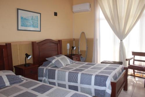 阿里卡的住宿－Hotel Sol de Arica，一间卧室设有两张床和窗户。