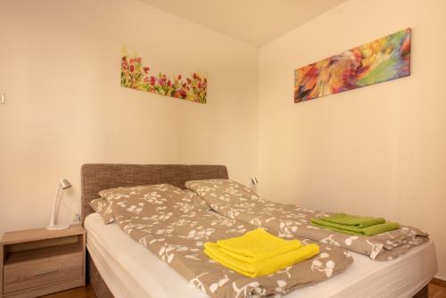 a bedroom with a bed with a yellow towel on it at Modor Apartman in Alsópáhok