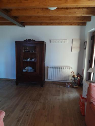 a living room with a wooden cabinet and wooden floors at Los Arroyos in San Martín de la Vega del Alberche