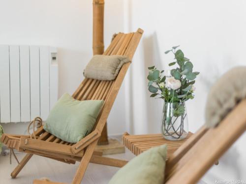 a rocking chair with pillows and a vase of flowers at Parede Ocean in Parede