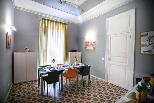 a dining room with a table and chairs and a white door at Belle Epoque B&B in Trapani