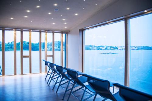 a row of chairs in a room with a view of the water at Gullmarsstrand Hotell & Konferens in Fiskebäckskil