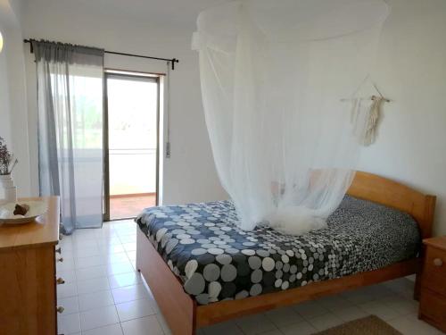 - une chambre avec un lit avec un rideau dans l'établissement Casa VILA CEIXE, à Odeceixe