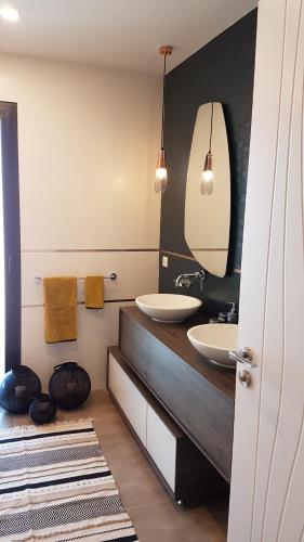 La salle de bains est pourvue de 2 lavabos et d'un grand miroir. dans l'établissement Apartment Cap Ostrea, à Andernos-les-Bains