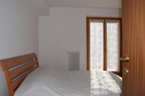 - une chambre avec un lit et une fenêtre dans l'établissement Dolomiti Apart, à Balbido-rango