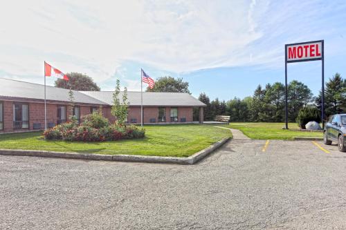 a motel sign in front of a building with two flags at King Hotel in Palmerston