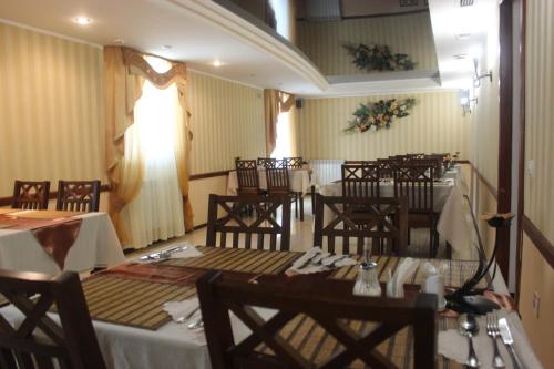 uma sala de jantar com mesas e cadeiras num restaurante em Вілла Анастасія em Truskavets