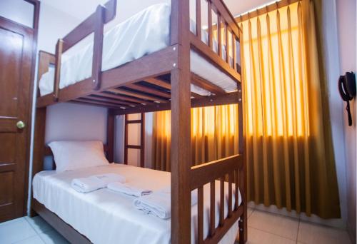 a bedroom with two bunk beds with white sheets at Hostal Vasco in Tacna