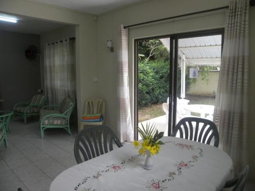 a dining room with a table and chairs and a patio at Arabica Villa in Flic-en-Flac