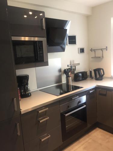 a kitchen with a stove and a microwave at Gite le Petit Puits à Richelieu in Richelieu