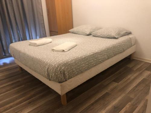 - un lit avec 2 serviettes blanches dans l'établissement Résidence Le Parc 68, à Colmar