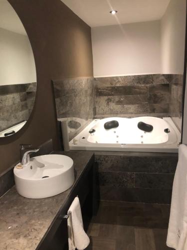 a bathroom with a bath tub and a sink at Hotel Isabel in Puebla