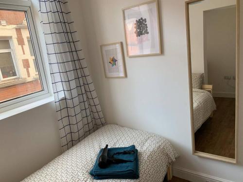 niebieska torba siedząca na łóżku obok lustra w obiekcie GRANBY APARTMENTS w mieście Leicester