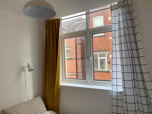 ventana en una habitación con sofá y cortina en GRANBY APARTMENTS, en Leicester