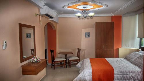 Schlafzimmer mit einem Bett, einem Tisch und Stühlen in der Unterkunft Olan´s Hotel Group in Esmeraldas