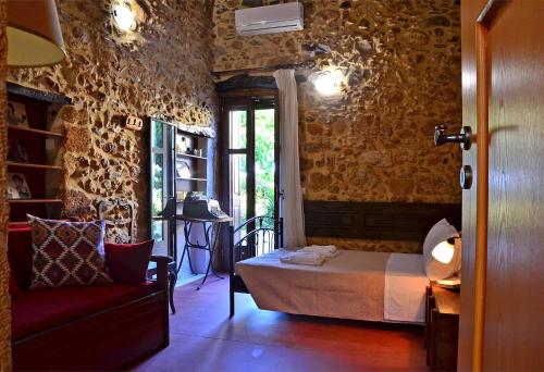 a bedroom with a bed and a chair in a room at Kamara Stone House in Kissamos