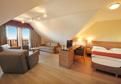 a hotel room with a bed and a couch at Hotel Saint Fiacre in Bourscheid