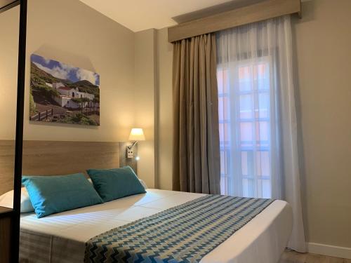 een slaapkamer met een bed voor een raam bij Mar de las Calmas in La Restinga