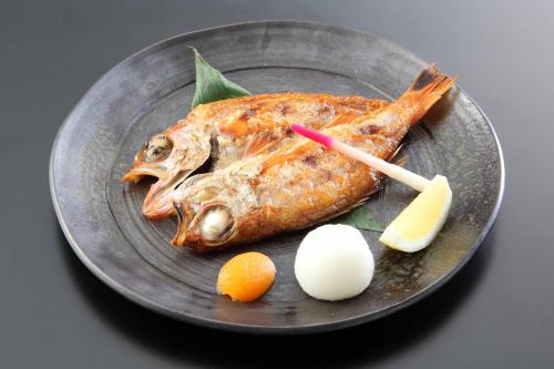 a plate of food with a fish and eggs on it at Hotel Futaba in Yuzawa