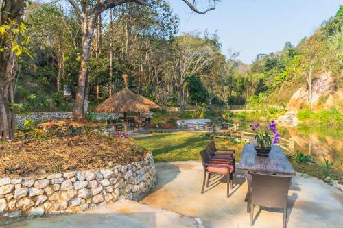 a patio with a table and chairs and a garden at Katiliya Mountain Resort And Spa in Mae Salong Nai