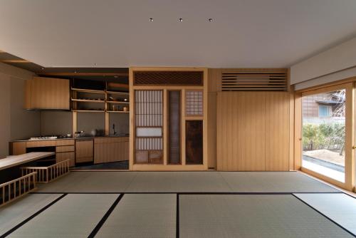 a kitchen with wooden cabinets and a large window at modern ryokan kishi-ke in Kamakura