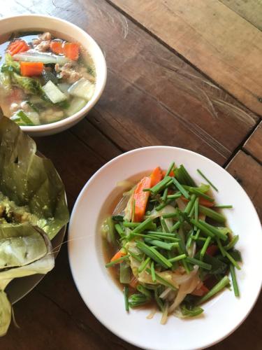 two bowls of soup and a bowl of vegetables on a table at Chansor Homestay 12 By Siem Reap Homesteading in Siem Reap