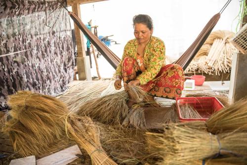 a woman sitting on top of a pile of hay at Chansor Homestay 12 By Siem Reap Homesteading in Siem Reap