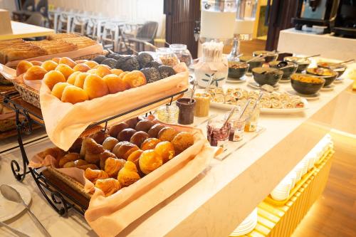 a buffet line with various types of bread and pastries at Howard Plaza Hotel Hsinchu in Hsinchu City