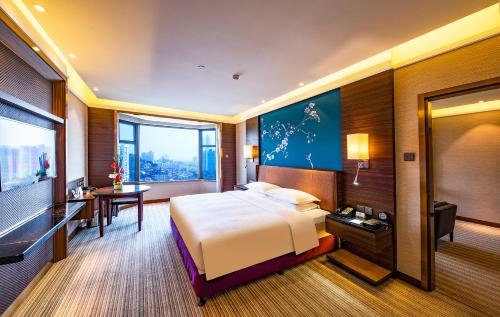 a hotel room with a bed and a desk at Millennium Harbourview Hotel Xiamen-Near Metro Station & Zhongshan Road in Xiamen