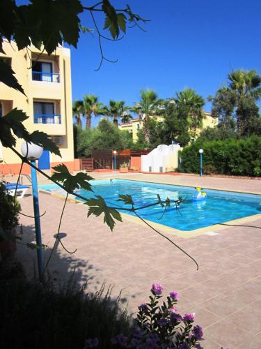 a swimming pool in front of a building at Georgia Apartments in Paphos City