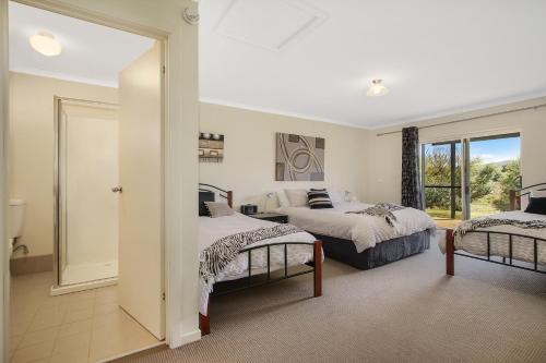 a bedroom with two beds and a mirror at Colonial Inn Guest Rooms in Yackandandah