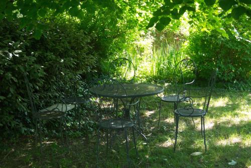 a table and four chairs sitting in the grass at Le Clos de l'Ambre in Divajeu