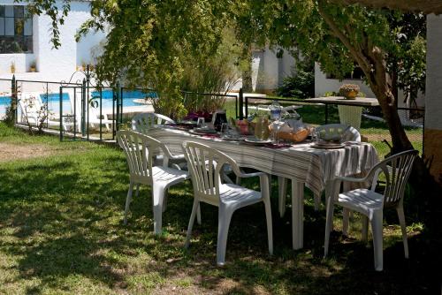 a white table with chairs and food on it at Quinta dos Álamos Agroturismo in Golegã