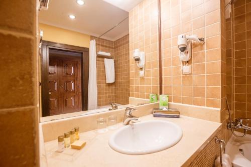 bagno con lavandino e specchio di Samal Resort & SPA a Almaty