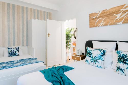 een slaapkamer met 2 bedden en een raam bij HolidayRento The Palm House Bondi in Sydney