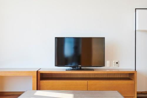a flat screen tv sitting on top of a wooden entertainment center at Lahan Hotel Pohang in Pohang