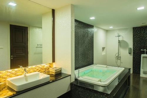 a bathroom with a bath tub and a sink at Marrakesh Huahin 4bedrooms suite with Jacuzzi 208 in Hua Hin