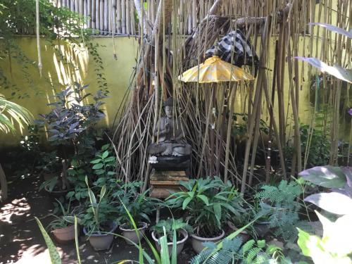 a garden with a statue in the middle of plants at Gili Nyepi in Gili Trawangan