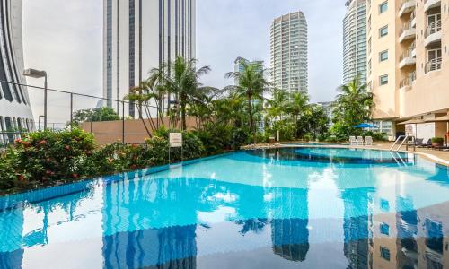a swimming pool in the middle of a city with tall buildings at Perdana Kuala Lumpur City Centre in Kuala Lumpur
