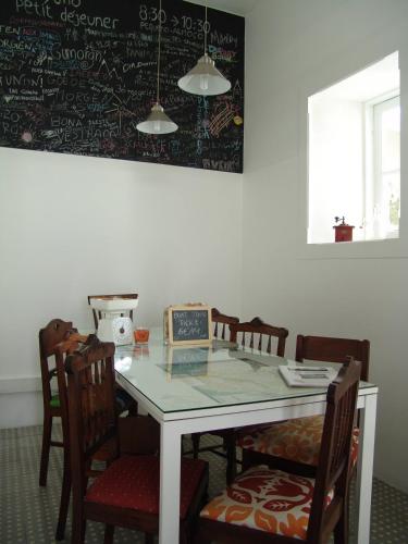 a dining room with a table with chairs and a chalkboard at Aveiro Rossio Hostel in Aveiro