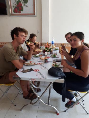 Eine Gruppe von Menschen, die an einem Tisch sitzen und Essen essen. in der Unterkunft Hotel Thanh Minh in Châu Làng Chánh