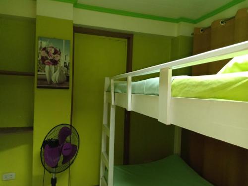a room with two bunk beds in a green room at A.C. Asistin Transient House in Baguio