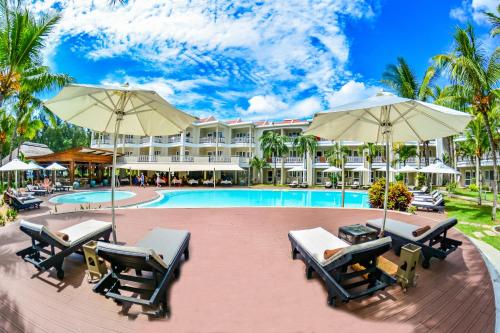 a resort with a pool and chairs and umbrellas at Tarisa Resort & Spa in Mont Choisy