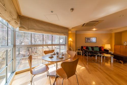 a living room with a table and chairs and a couch at Fuji Premium Resort in Fujikawaguchiko