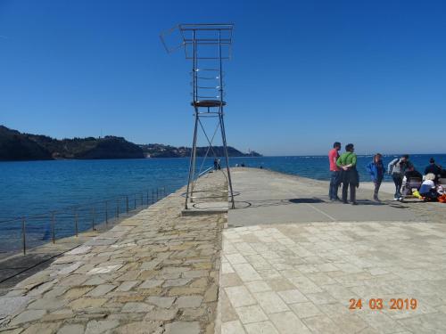 people standing on a pier next to the water at Heart of Strunjan Apartments AL in Strunjan